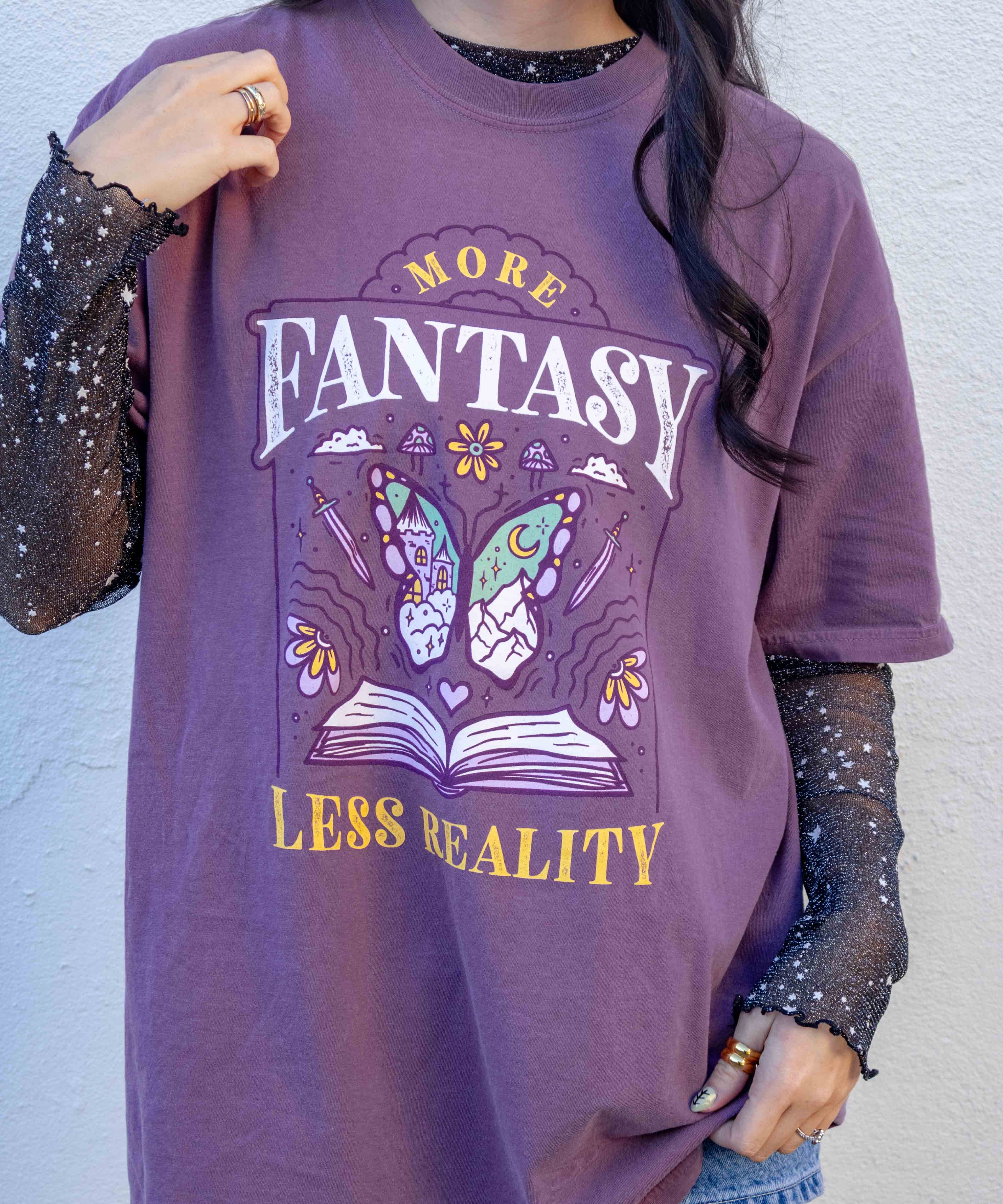 A purple t-shirt More Fantasy Less Reality, with a bookish graphic, Fantasy Romance merch, Gift for readers