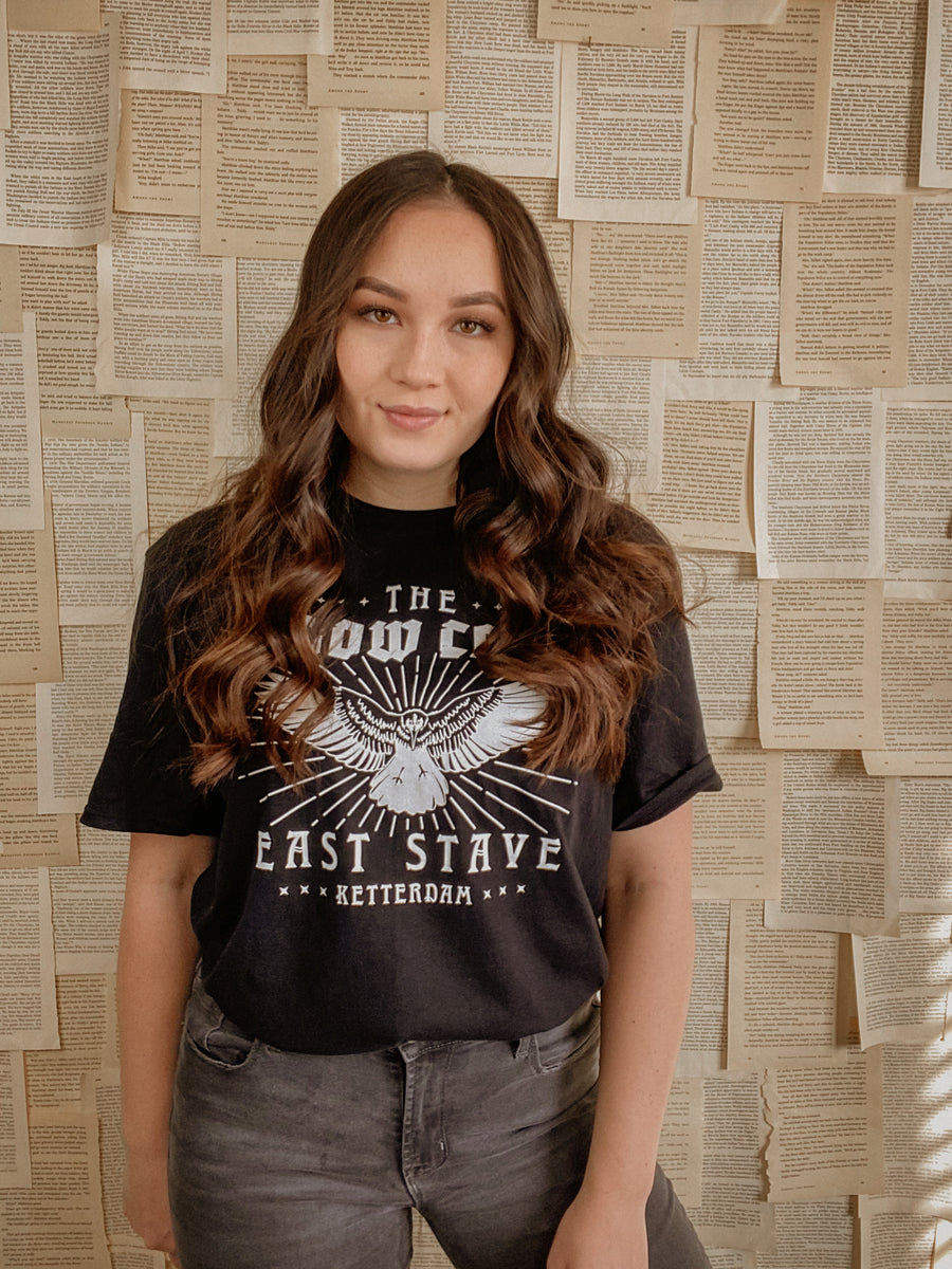 model standing in front of wall full of pages wearing crow club shirt