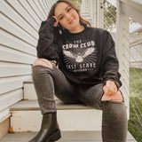 model woman sitting on stairs with crow club sweatshirt on
