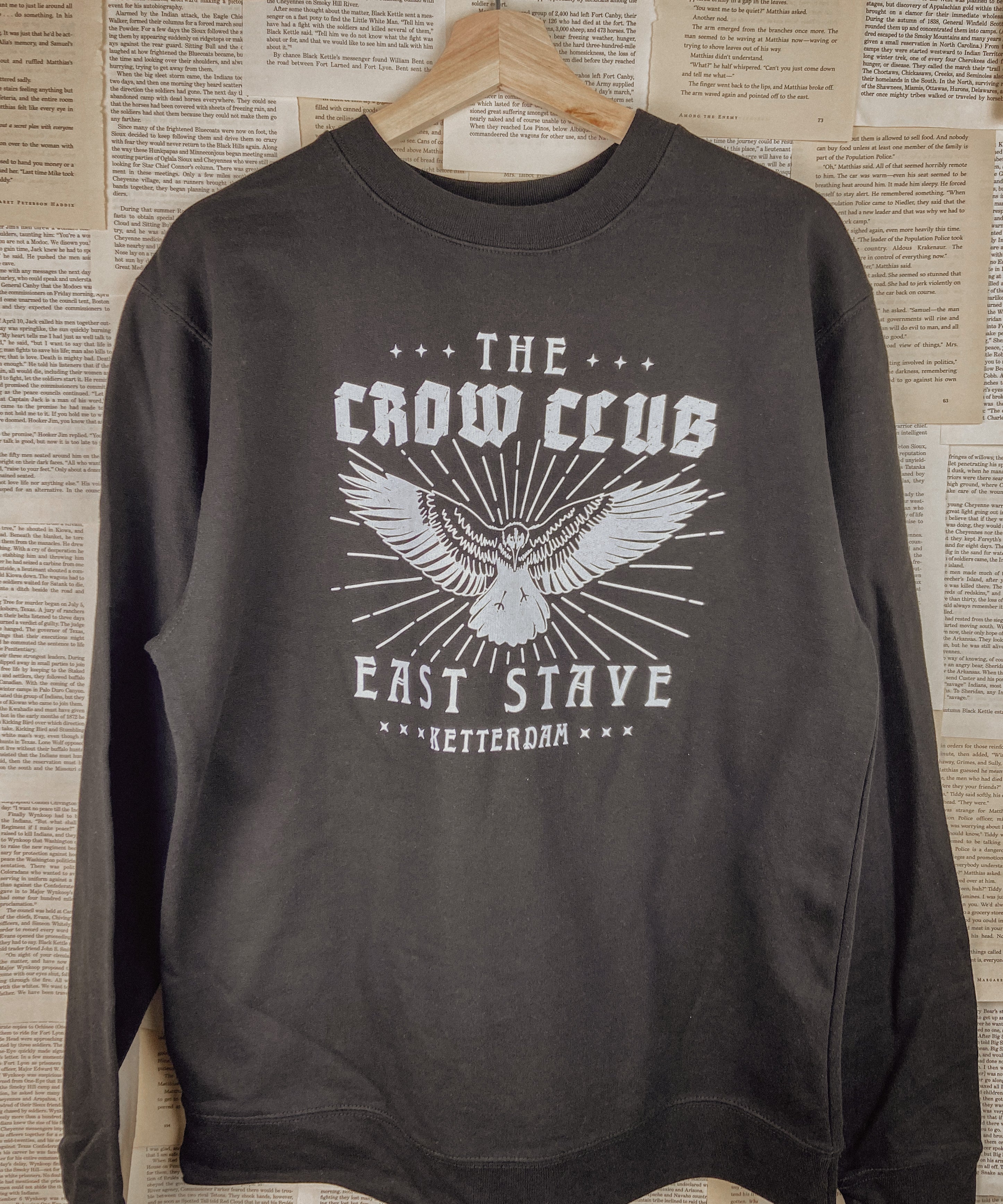 a crow club sweatshirt hung up